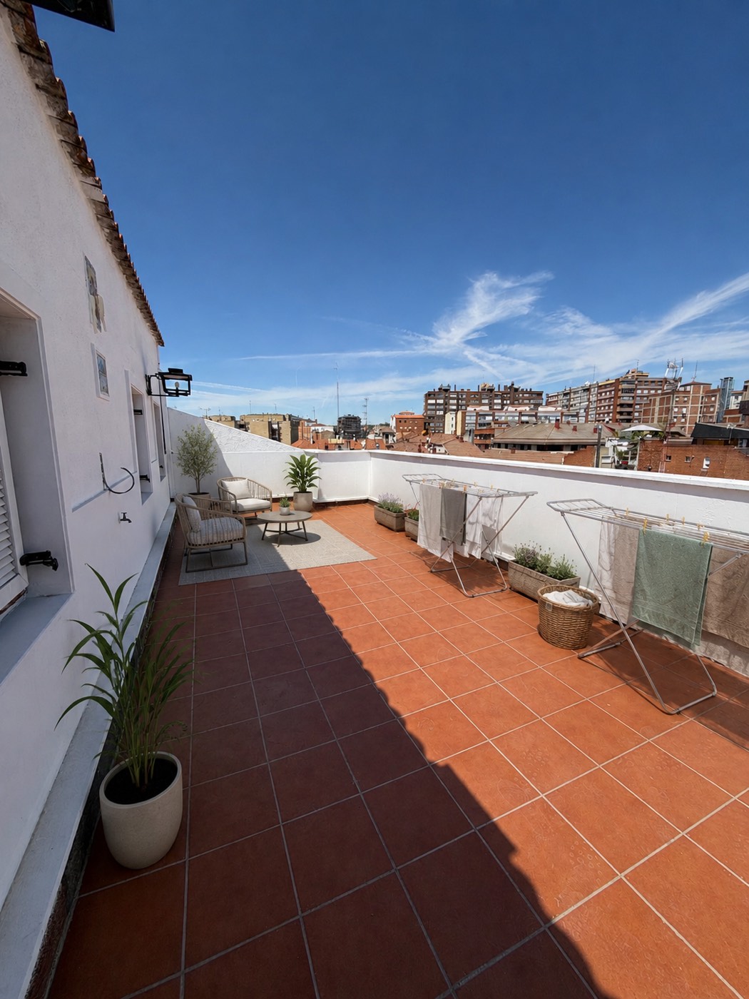 Terraza en la azotea con tendederos y cielo azul de verano